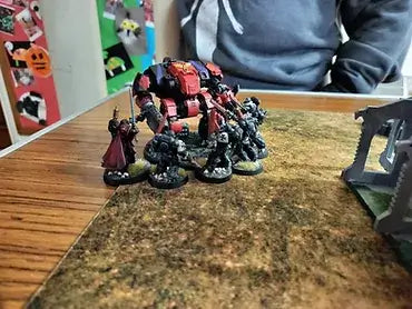 A close-up of miniatures and a large robot on a gaming table during the first day of the Breaney-Hammer league.